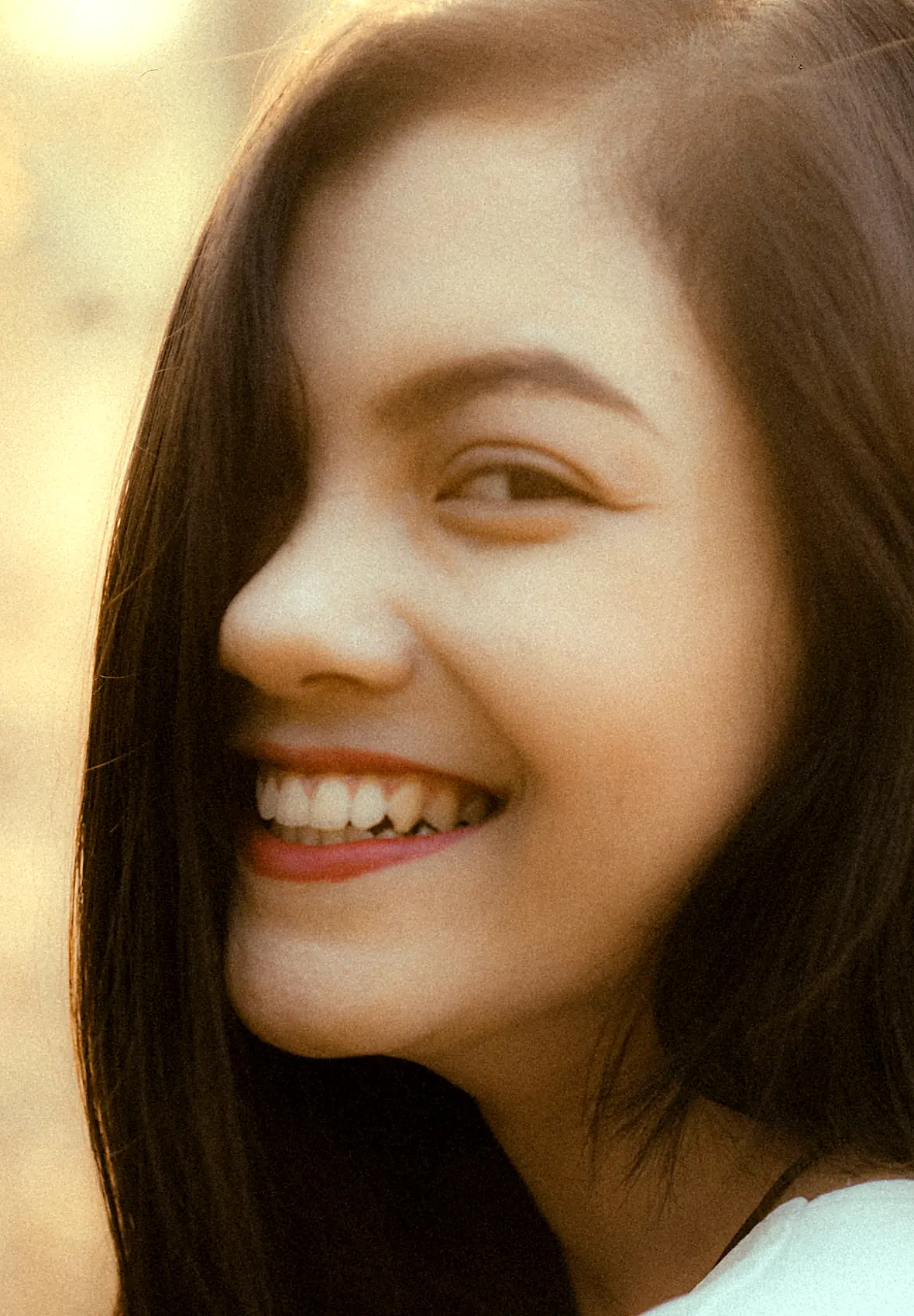 A young woman laughing, showing a bright, healthy smile