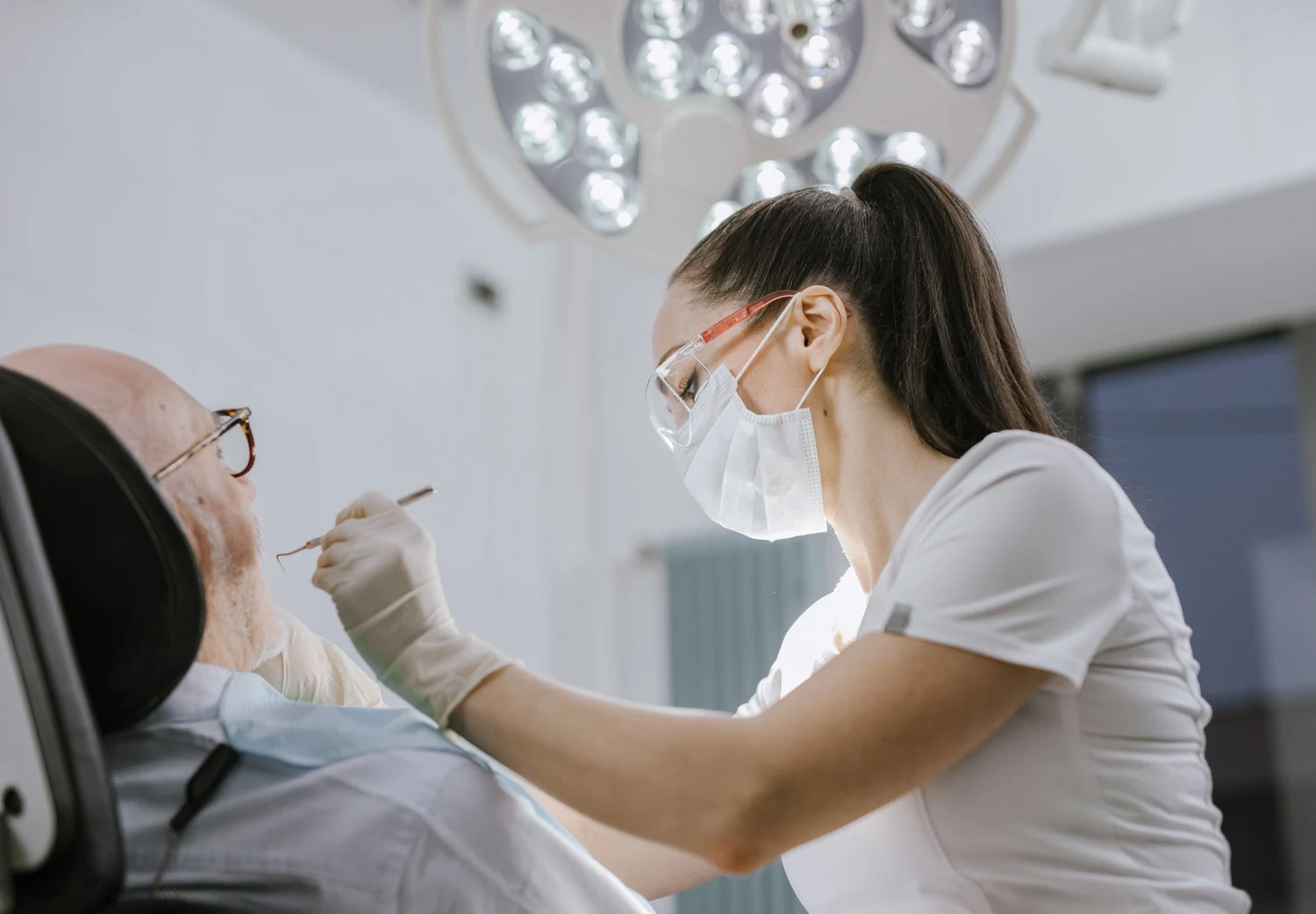 A dentist examining a patient&rsquo;s teeth