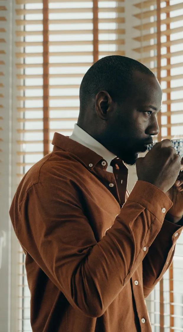 A man drinking his morning coffee by a window — the coffee ritual behind Java Burn