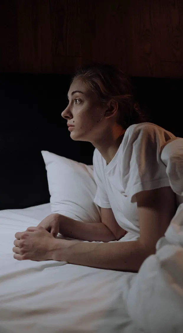 A woman lying awake in bed in the early hours — the broken sleep a deep sleep supplement targets